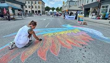 A woman draws in chalk at the Stonetown Heritage Festival, summer 2024. Photo provided by the Town of St. Marys.