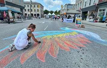 A woman draws in chalk at the Stonetown Heritage Festival, summer 2024. Photo provided by the Town of St. Marys.