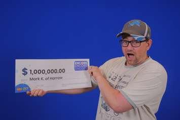 Mark Keltika of Harrow shows off his million-dollar cheque at the OLG Prize Centre in Toronto. Photo courtesy Ontario Lottery and Gaming.