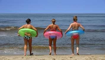 Three people on a beach. File photo courtesy of © Can Stock Photo / keeweeboy.