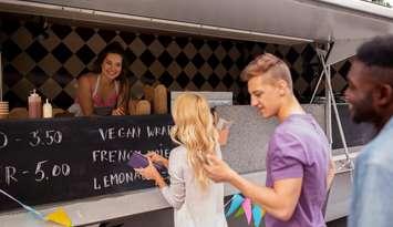 Happy Customers Queue At Food Truck @CanStock photo by dolgachov